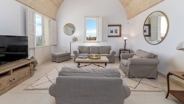 Una sala de estar con televisión, sofás, una mesa de centro y una chimenea.