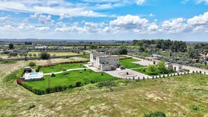 Una extensa propiedad con piscina, patio y vistas al campo circundante.
