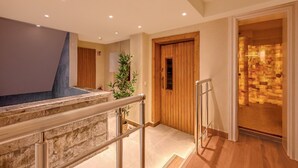 A hotel lobby with a stone wall, a wooden door, and a tiled floor. - Sunday Schwarzbachtal Wheelchair Accessible Room (Markneukirchen)