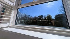 Una ventana con vistas a árboles y un cielo despejado.