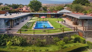 Ein Poolbereich mit freiem Blick auf die umliegende Landschaft, einschließlich eines Gebirges in der Ferne.