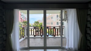 Un balcón con vista a un paisaje urbano, que muestra edificios y un cielo despejado.