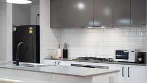 A modern kitchen with a central island, stainless steel appliances, and a black faucet.