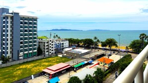 A coastal cityscape with a large hotel, a beach, and a marina. - Sea View Studio - Jomtien Beachfront - View Talay 8 (Muang Pattaya)