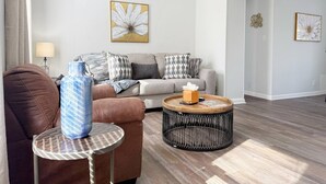 A modern living room with a sofa, a coffee table, and a side table. - Riverside A2 - QUEEN 2BD/1BA Apt near River (Evansville)