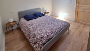 Une chambre à coucher avec un lit, une lucarne, un plafond en bois et une armoire.