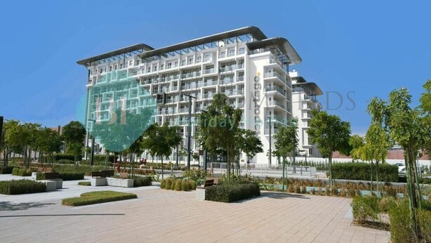 A modern multi-story hotel with a glass facade, surrounded by landscaped gardens and a paved walkway. - Bloomfields Magnificent STU in Oasis (Abu Dhabi)