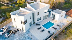 A modern two-story house with a swimming pool, a covered patio, and a garage with two cars. - Beautiful home in Krk with sauna (Krk)