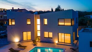 A modern two-story building with a swimming pool and lounge chairs. - Beautiful home in Krk with sauna (Krk)