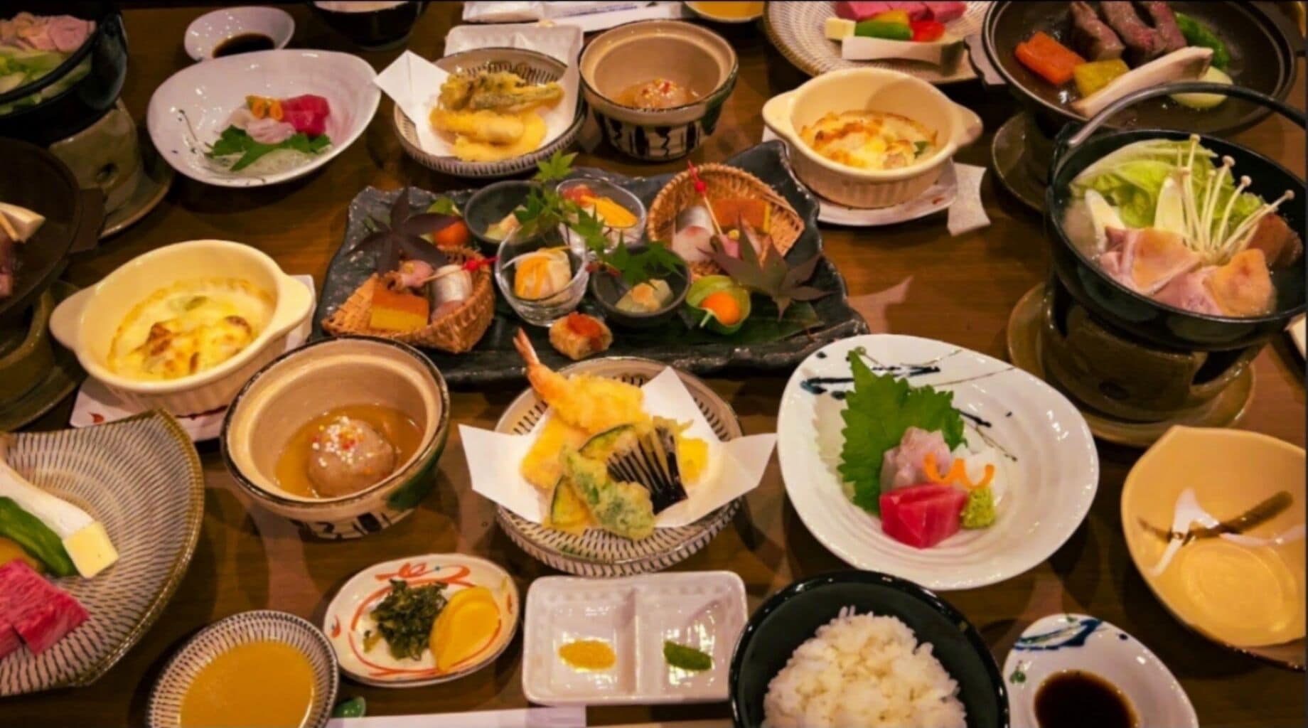 Une variété de plats et d’aliments sont disposés sur une table, notamment des sushis, des sashimis et d’autres spécialités de la cuisine japonaise.