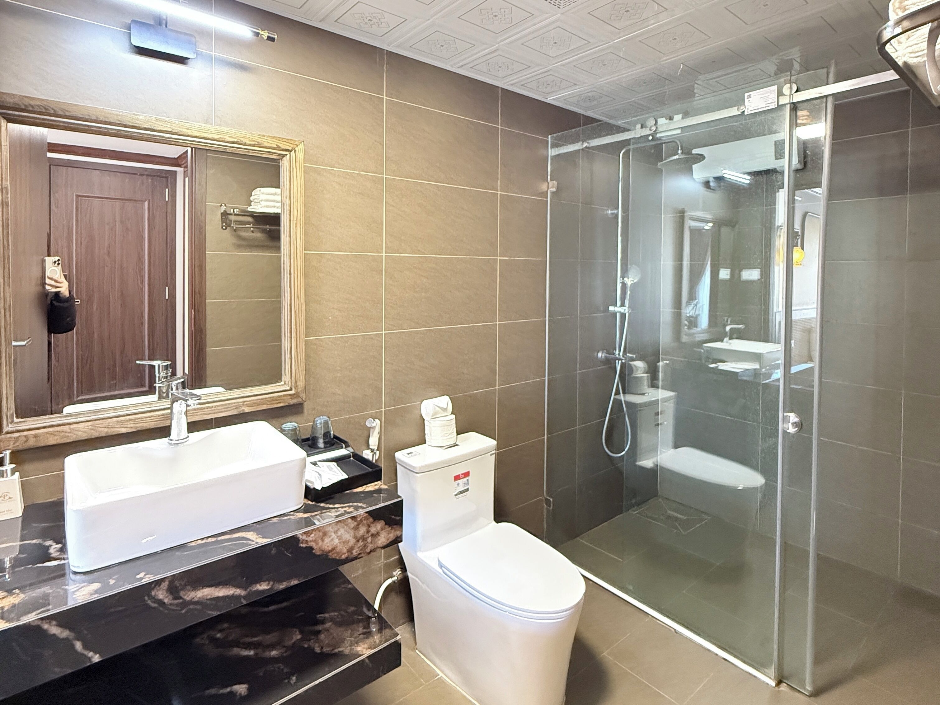 A modern bathroom with two sinks, a toilet, and a glass-enclosed shower.