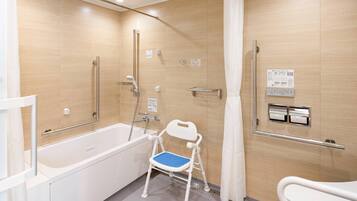 A modern bathroom with a bathtub, shower, and toilet.