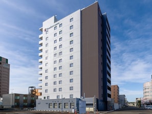 Un hotel alto y moderno con un llamativo letrero Comfort Hotel, varios pisos y una fachada plana.