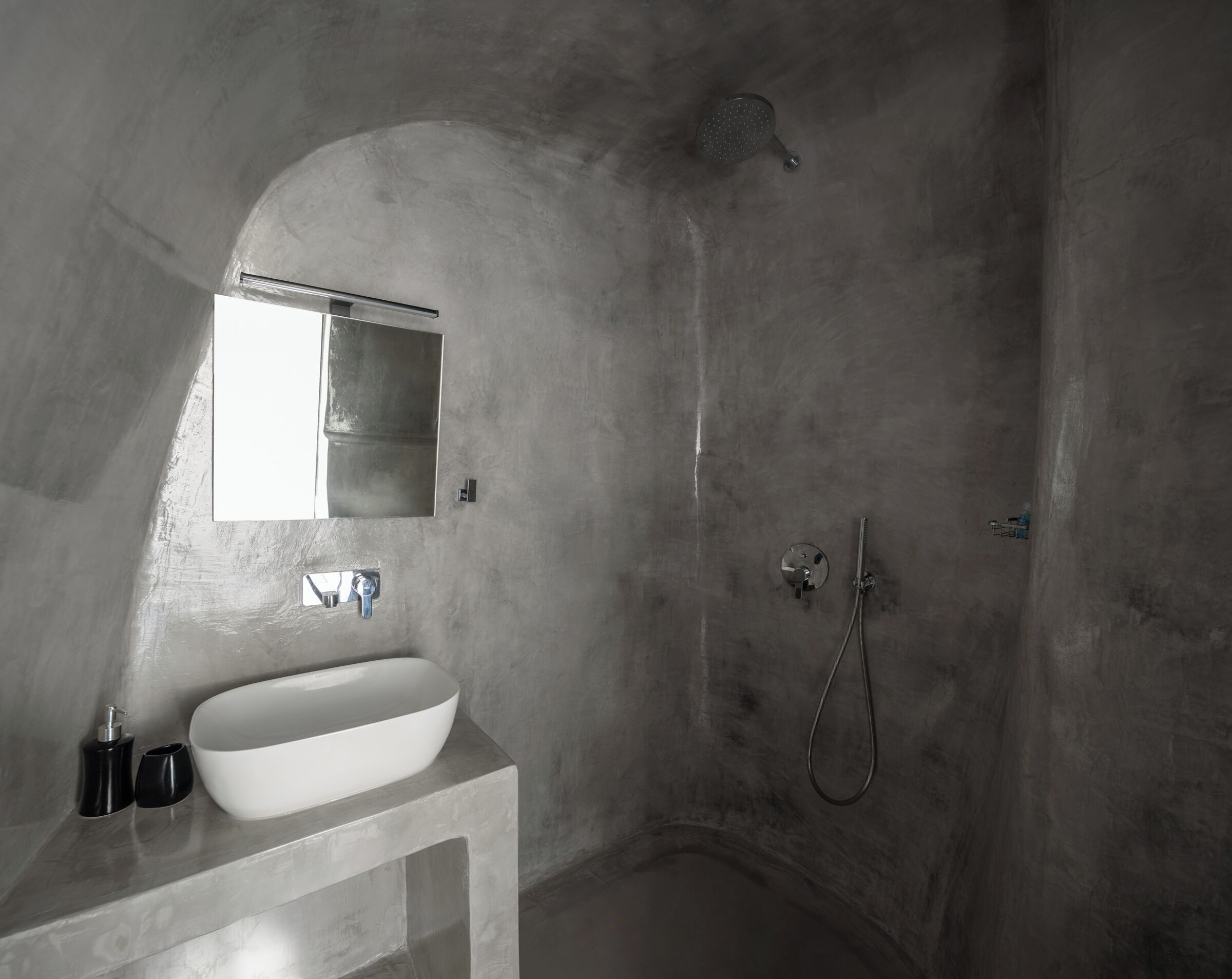 A bathroom with a white sink, a mirror, and a shower.