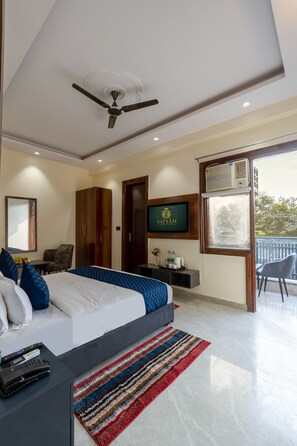 Una habitación de hotel moderna con cama, televisor, escritorio y balcón.