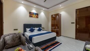 Una habitación de hotel moderna con una cama grande, un escritorio con frutero, un control remoto y un ventilador de techo.