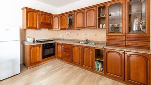 Una cocina con armarios de madera, horno empotrado, lavavajillas y un fregadero.