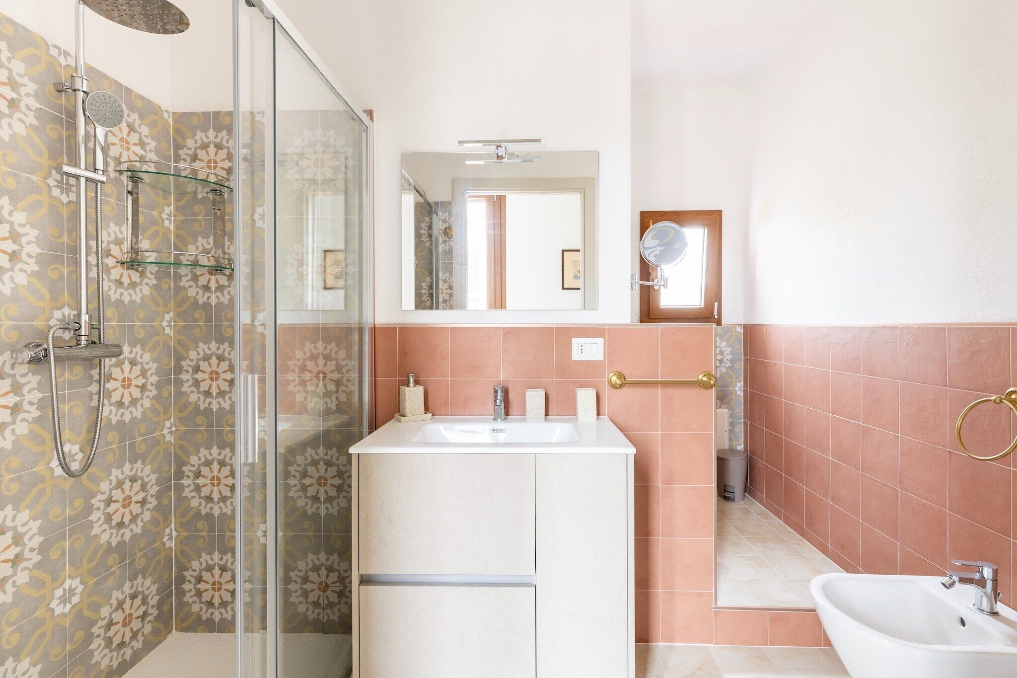 A bathroom with a shower, sink, and mirror.