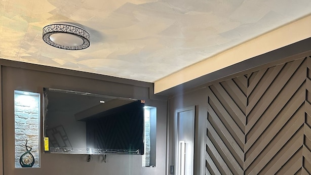 Un salón moderno con chimenea, televisor de pantalla plana y pared con patrón de espiga.