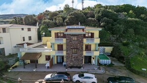 Ein zweistöckiges Haus mit Balkon, Steinaußenwand und Rasen.