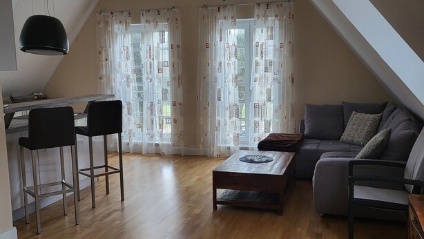 A modern loft apartment with a dining area, a sofa, and a coffee table. - Welcome to our Gala vacation apartment (Stade)