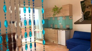 A modern kitchen with wooden cabinets, a built-in dishwasher, and a tiled backsplash. - Mini Apartment in a Farm House on the High Hills Near Gubbio (Gubbio)
