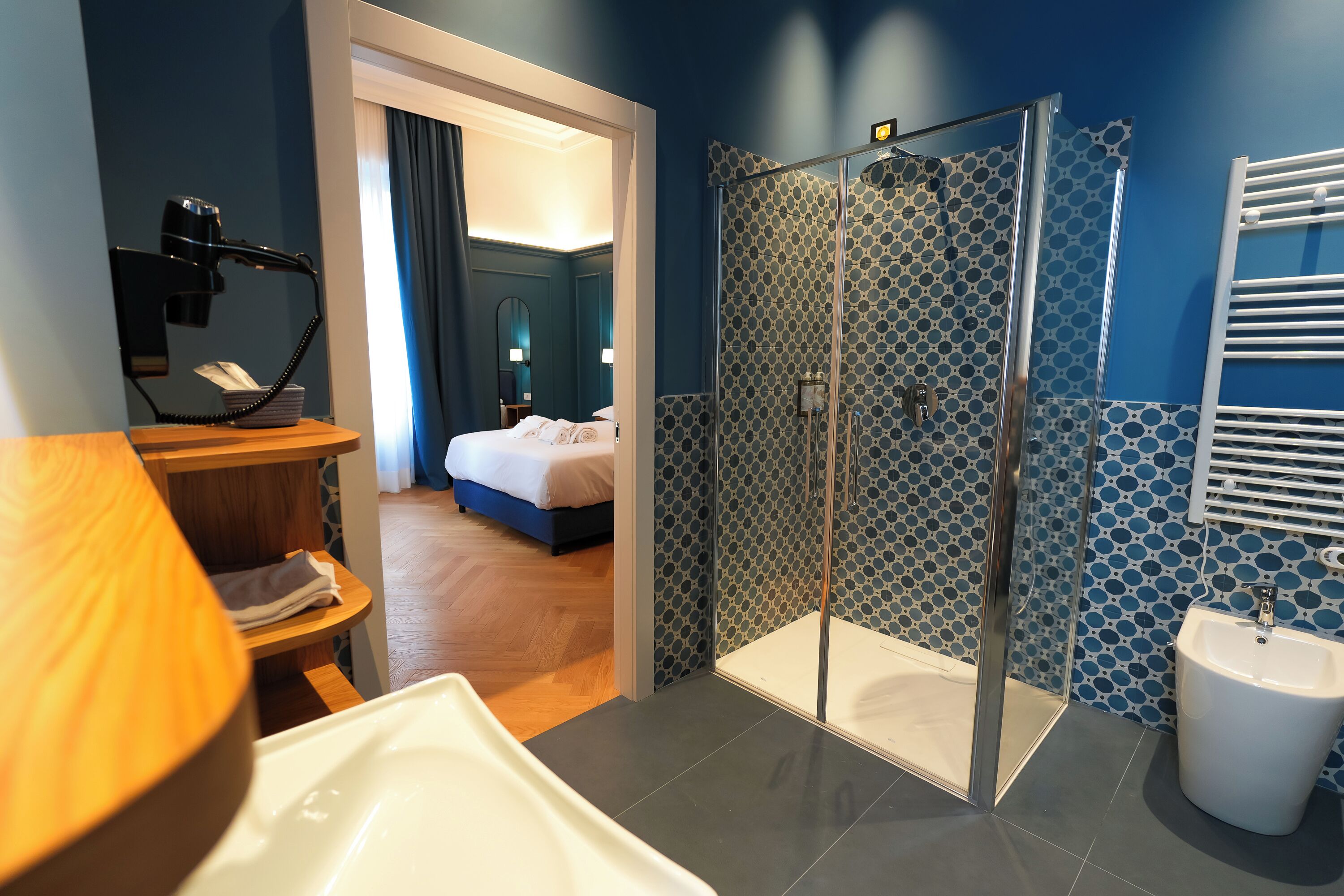Une salle de bain moderne avec une douche, un lavabo et un miroir.
