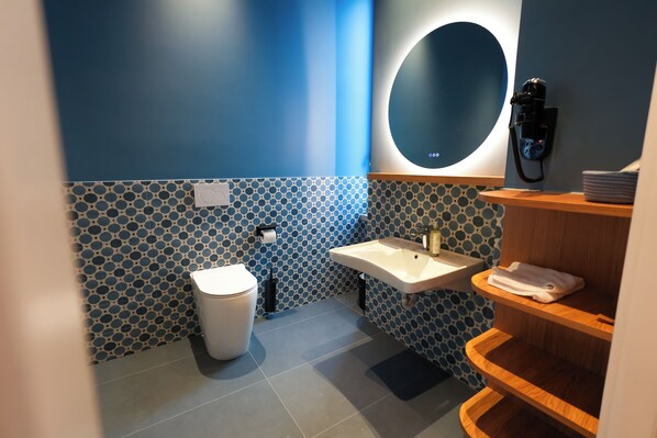 Ein modernes Badezimmer mit Toilette, Waschbecken und Spiegel.