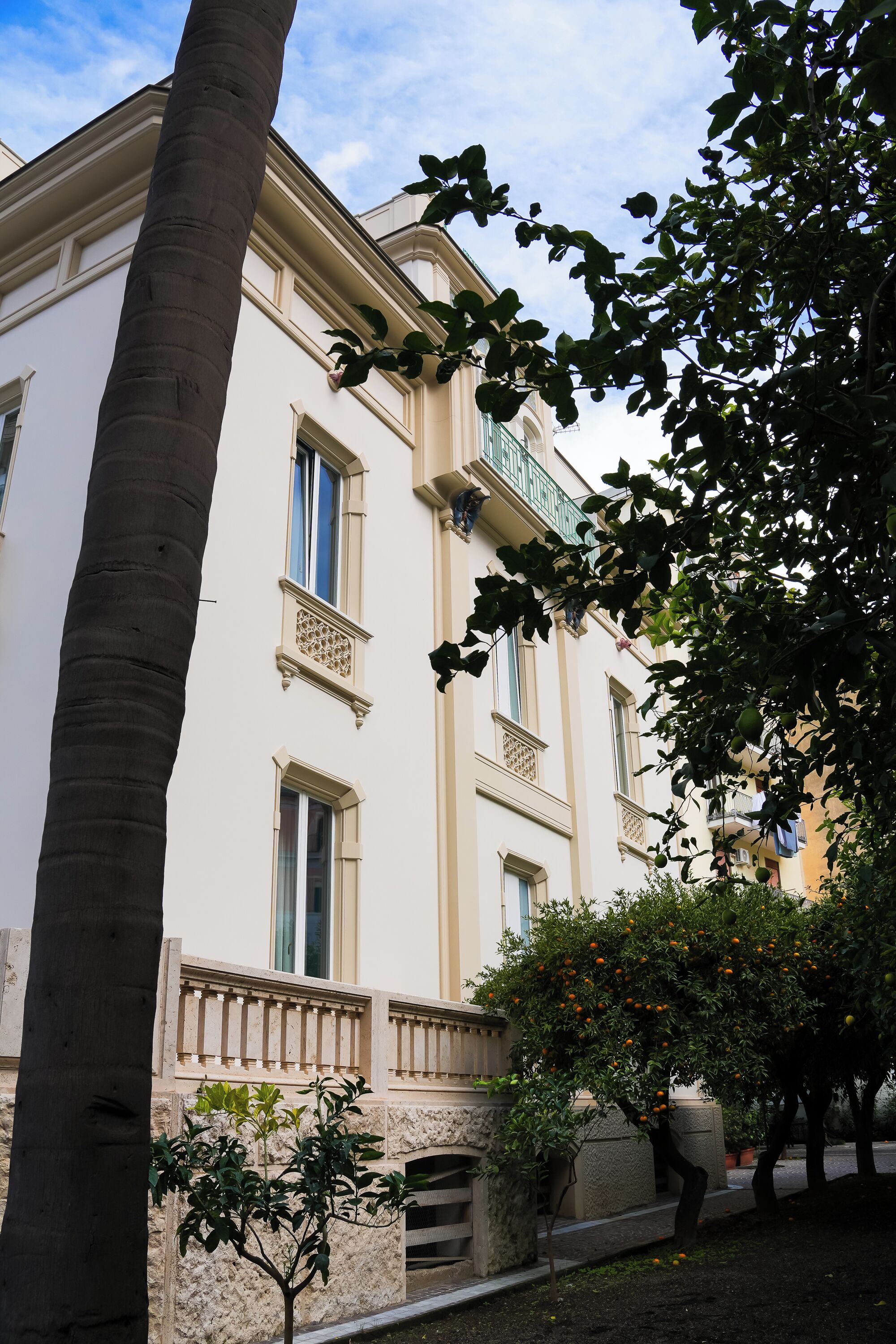 En byggnad i klassisk arkitektonisk stil, med en balkong som har utsmyckade räcken och en grund av sten.