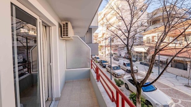 A balcony with a view of parked cars and buildings. - Hotel Venera (Sarande)