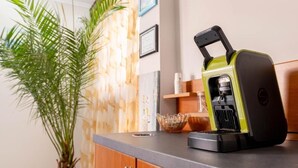 A kitchen counter with a coffee machine, a potted plant, and a decorative wall panel. - Hotel Venera (Sarande)