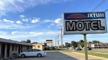 A motel with a clear sky and a parked car in front.