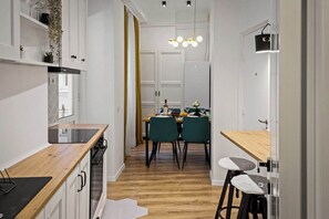 Eine moderne Küche mit Holzarbeitsplatte, einem eingebauten Backofen und einem Essbereich mit Tisch und Stühlen.