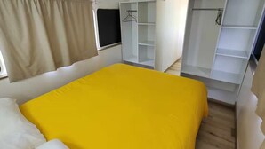 A room with a bed, a wardrobe, and a mirror. - Cozy 1-bedroom Caravan In Bourail with AC (Bourail)