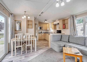 Ein kompakter Wohnbereich mit Essplatz, Küchenzeile und Sofa.