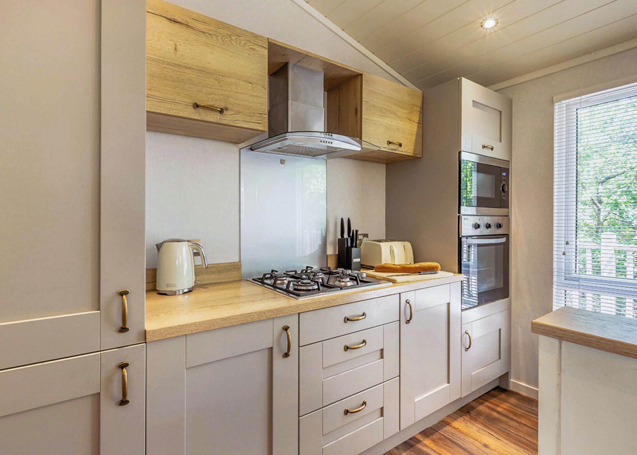 A modern kitchen with a gas stove, a toaster, and a built-in oven.