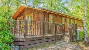 Une cabane en bois dotée d’une véranda, d’un escalier et d’une enseigne indiquant qu’il s’agit d’un lieu de retraite pour les pêcheurs.