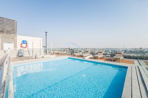 Ein Pool auf dem Dach mit Liegestühlen und einem Rettungsring.