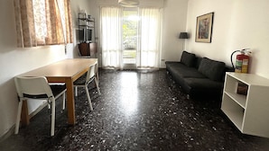 Ett kompakt bostadsutrymme med en matplats, en soffa och en tv.