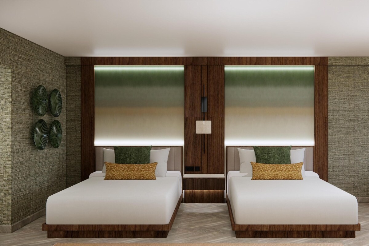 A modern bedroom with two beds, a wooden accent wall, and a herringbone floor pattern.