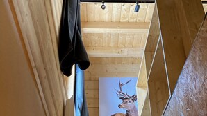 Eine Holztreppe führt zu einem Raum mit Holzboden und einem Bild von einem Hirsch in einem Rahmen.