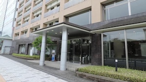 Un hotel a più piani con ingresso coperto, ampie finestre e un design architettonico moderno.