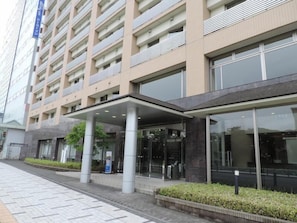 Un hôtel à plusieurs étages doté d’une entrée couverte, de grandes fenêtres et d’une architecture moderne.