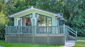 A small, single-story cabin with a covered porch and a staircase leading to a deck. - Superior Lodge with ensuite & decking (Near Weymouth)
