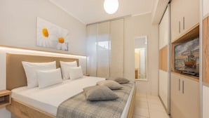 Ein modernes Schlafzimmer mit einem großen Bett, einem Kopfteil, einem Nachttisch, einem Spiegel und einem Kleiderschrank.