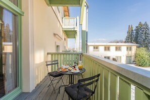 A balcony with a table set for breakfast, chairs, and a view of the city. - Villa Kaiserhof 05: Elegant vacation apartment with a balcony near the beach in Zinnowitz (Zinnowitz)