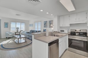 A modern kitchen with white cabinets, a stainless steel stove, and a dishwasher. - Oceanfront Home + Pool Access + Balcony + Beach Access | 301 F Port O Call (Isle Of Palms)