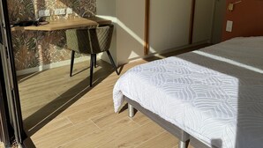 Una camera da letto con un letto, una scrivania e una sedia.