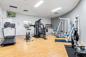 A gym with a treadmill, elliptical, weight machines, and a rowing machine. - Bright Inner-City Stay Near River View (Brisbane City)