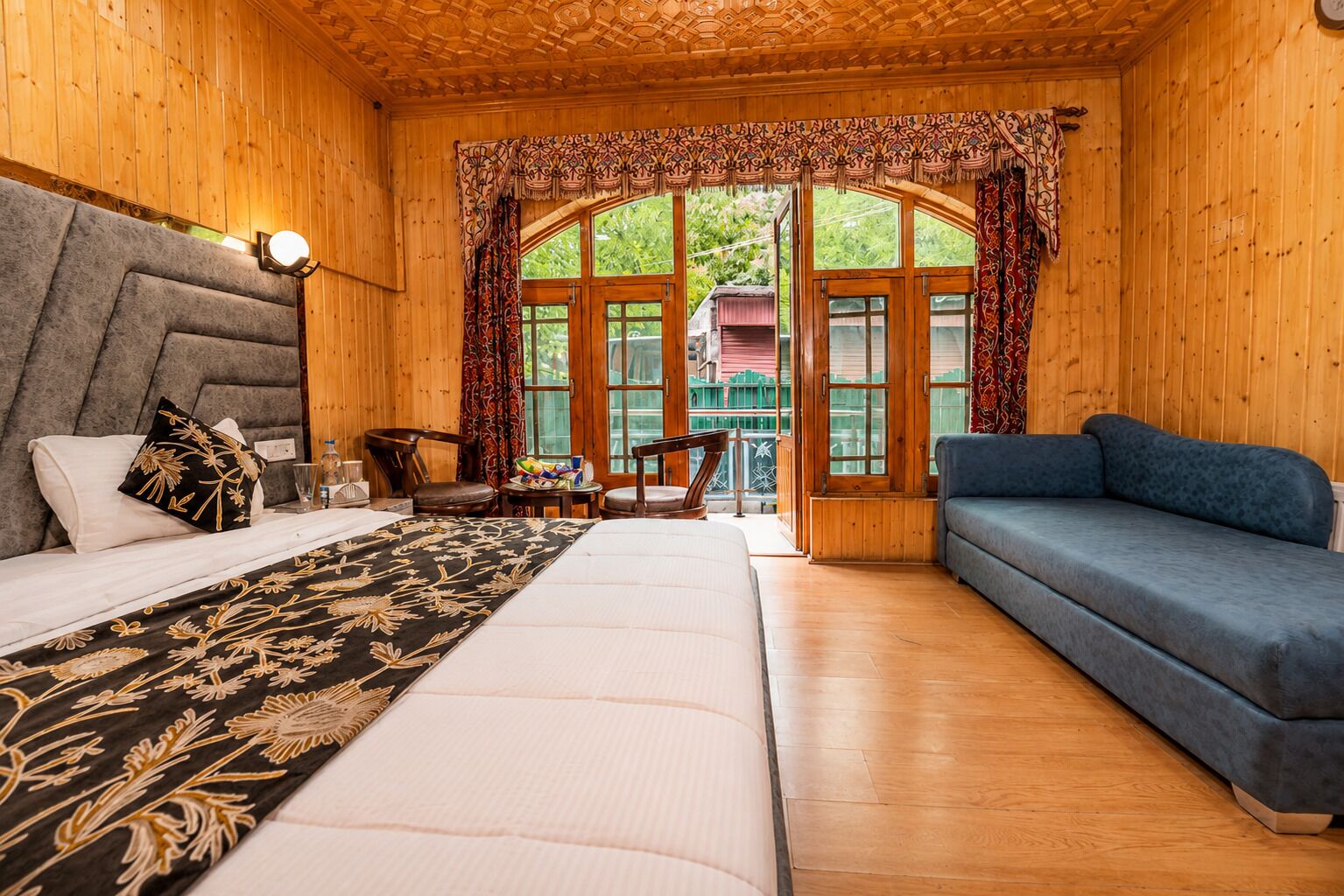 Una habitación de cabaña de madera con una cama, sofá y sillones.